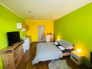a green room with a bed and a kitchen at Apartmán Slivková in Trenčín