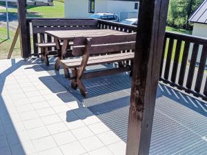 drewniany stół i ławka na pokładzie w obiekcie Holiday Home Holiday Hill 44 by Interhome w mieście Lauterwasser