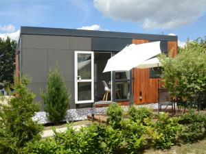 a tiny house with a large window and an umbrella at Holiday Home Tiny Haus Altmühlblick Nr- 83 by Interhome in Beilngries