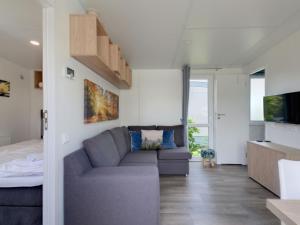a living room with a couch and a tv at Holiday Home Tiny Haus Altmühlblick Nr- 83 by Interhome in Beilngries +16 photos