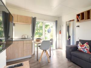 Una cocina y una sala de estar con una mesa y un sofá. en Holiday Home Tiny Haus Altmühlpanorama by Interhome, en Beilngries