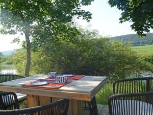 una mesa de madera con sillas y una mesa con en Holiday Home Tiny Haus Altmühlpanorama by Interhome, en Beilngries