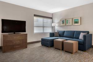 un salon avec un canapé bleu et une télévision à écran plat dans l'établissement Comfort Inn & Suites Downtown Brickell-Port of Miami, à Miami