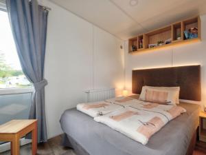 ein Schlafzimmer mit einem großen Bett mit Fenster in der Unterkunft Holiday Home Tiny Haus Lieblingsplatz by Interhome in Beilngries