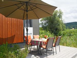 einen Tisch und Stühle unter einem Schirm auf einer Terrasse in der Unterkunft Holiday Home Tiny Haus Lieblingsplatz by Interhome in Beilngries