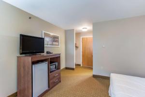a hotel room with a flat screen tv and a bed at Quality Inn & Suites Gorham Riverside in Gorham