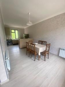 a dining room with a table and chairs and a kitchen at Grand Villa Sadgeri in Borjomi