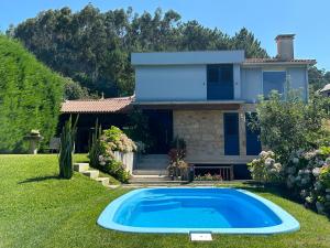 dom z niebieskim basenem na dziedzińcu w obiekcie Batán - Preciosa casa en el Valle del Salnés w mieście Pontevedra