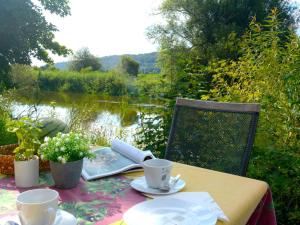 a table with plates and cups and a view of a lake at Holiday Home Tiny Haus Renate by Interhome in Beilngries
