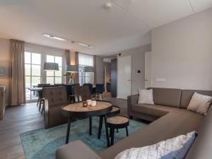 a living room with a couch and a table at Holiday Home Ganuenta-1 by Interhome in Colijnsplaat +22 photos
