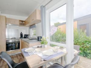 バイルングリースにあるHoliday Home Tiny Haus Kiwi by Interhomeのキッチン(テーブル、椅子付)、大きな窓が備わります。