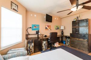 a bedroom with a bed and a desk and a tv at Chic Renovated Oasis- Disney & Universal Nearby home in Palm Bay