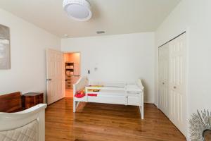 a white room with a bed and a hallway at Chic Renovated Oasis- Disney & Universal Nearby home in Palm Bay