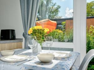 Una mesa con platos y vasos y un jarrón con flores. en Holiday Home Tiny Haus Conny by Interhome, en Beilngries
