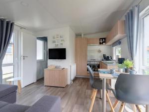 バイルングリースにあるHoliday Home Tiny Haus Leitner by Interhomeのテーブルとキッチンのあるリビングルーム