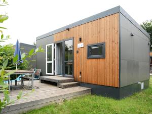 a tiny house on a deck with a table at Holiday Home Tiny Haus Heidi by Interhome in Beilngries