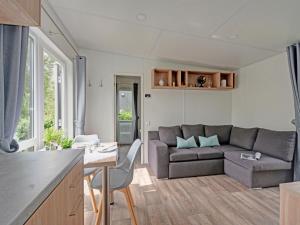 a kitchen and living room with a couch and a table at Holiday Home Tiny Haus Sonnendeck by Interhome in Beilngries +20 photos