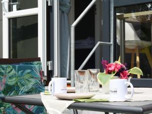 Una mesa con dos tazas y un jarrón con flores. en Holiday Home Tiny Haus Altmühlblick by Interhome, en Beilngries