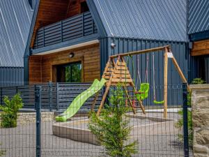 a playground with a slide in front of a building at Holiday Home Vuk by Interhome in Kupjak