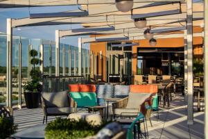 a patio with tables and chairs on a building at Tempo By Hilton Louisville Downtown Nulu in Louisville