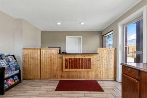 a kitchen with wooden cabinets in a room with a window at Rodeway Inn Hermiston - Umatilla in Hermiston