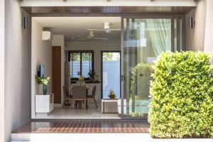 una puerta de cristal de una casa con mesa y sillas en SUNWAY 2BD Modern Townhouse, en Koh Samui 