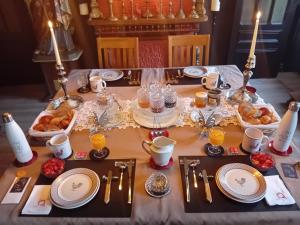 a table with a table set with food on it at Au champ du coq in Sepmeries