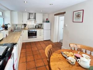a kitchen and dining room with a table and chairs at Magnolia Cottage in Porlock +16 photos