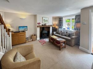 a living room with a couch and a fireplace at Magnolia Cottage in Porlock