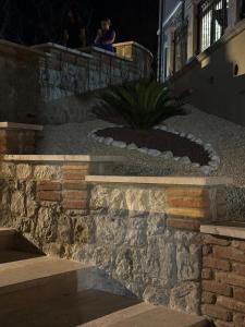 a person sitting on the ledge of a stone wall at TENUTA ROSA - Gastronomia e Relax in Montesano Scalo +74 photos
