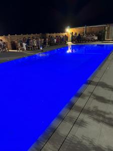 a swimming pool lit up blue at night at TENUTA ROSA - Gastronomia e Relax in Montesano Scalo