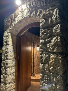 a stone wall with a wooden door in a room at TENUTA ROSA - Gastronomia e Relax in Montesano Scalo