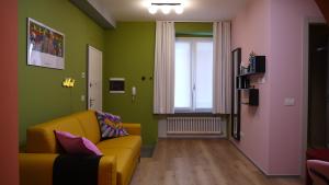a living room with a yellow couch and green walls at Pop House - Monza Park in Villasanta