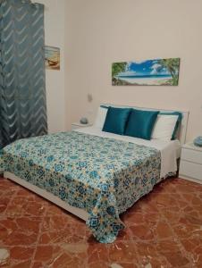 sypialnia z dużym łóżkiem z niebieskimi poduszkami w obiekcie B&B Casa Blanca w mieście San Vito lo Capo