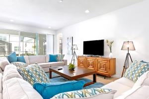 ein Wohnzimmer mit weißen Möbeln und einem Flachbild-TV in der Unterkunft Family-Friendly Mansion at Sonoma Luxury Resort in Kissimmee