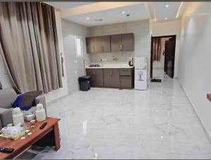 a kitchen with a table and a counter top at سما راف للشقق المخدومة التصنيف اقتصادي in Al Qurayyat