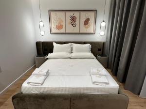 a bedroom with a large bed with white sheets at Villa MARTO in Sarandë