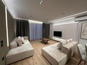 a living room with two couches and a flat screen tv at Villa MARTO in Sarandë
