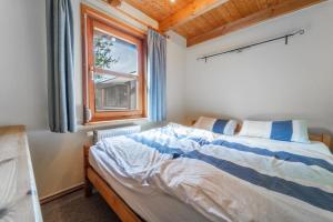 a bedroom with a bed and a window at Gemütliches Ferienhaus an der Eider in Bargen