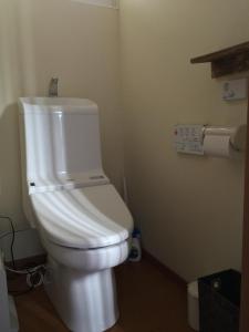 Guesthouse TOMAYA في نيمورو: حمام مع مرحاض أبيض في الغرفة