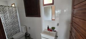 a small bathroom with a toilet and a sink at Gombela Ecolodge and Farming in São Tomé