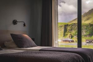 a bedroom with a bed and a window with a view at Hótel Kría in Vík