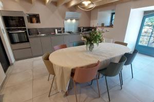 a kitchen with a table with a vase of flowers on it at Gite 8 personnes Ussel Grande Maison rénovée in Ussel