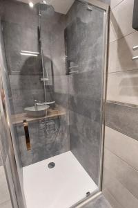 a shower with a glass door and a sink at Gite 8 personnes Ussel Grande Maison rénovée in Ussel +8 photos