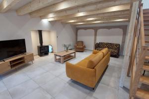a living room with a couch and a tv at Gite 8 personnes Ussel Grande Maison rénovée in Ussel