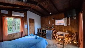 a bedroom with a bed and a table and a sink at Cabañas Bruma de Monte in El Soberbio