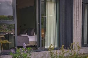 a bedroom with a bed outside of a window at Hótel Kría in Vík