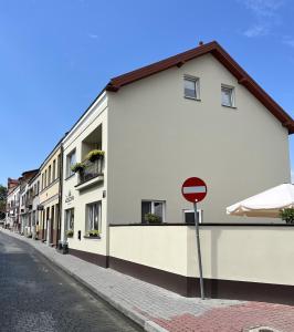 un edificio blanco en una calle con una señal de stop en Apartamenty Mostowa - klimatyczny nocleg z widokiem w centrum Iłży, en Iłża
