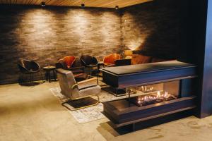 a living room with a fireplace and chairs at Hótel Kría in Vík