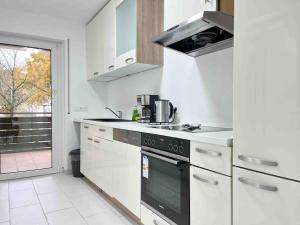 a white kitchen with a stove and a window at LAP101 - Große Moderne Monteurwohnung Übergangswohnung in Lappersdorf